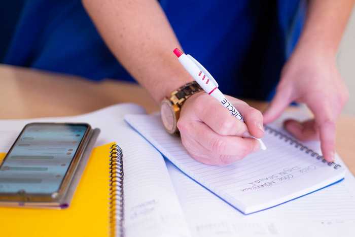 Person writing notes on a notepad